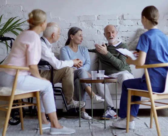 Two nurses talking to a senior couple